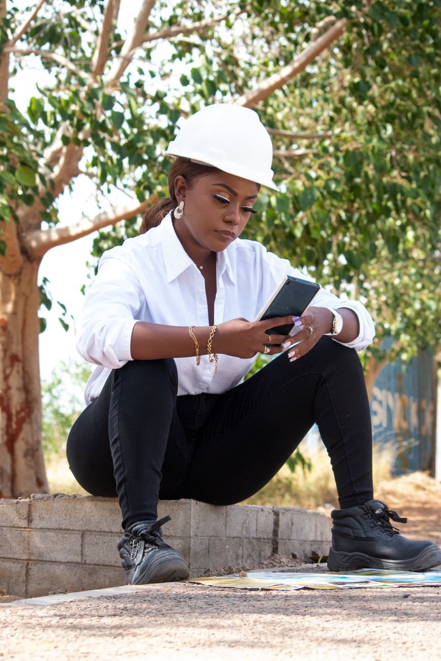 Engineer in hard hat using smartphone on a commercial site